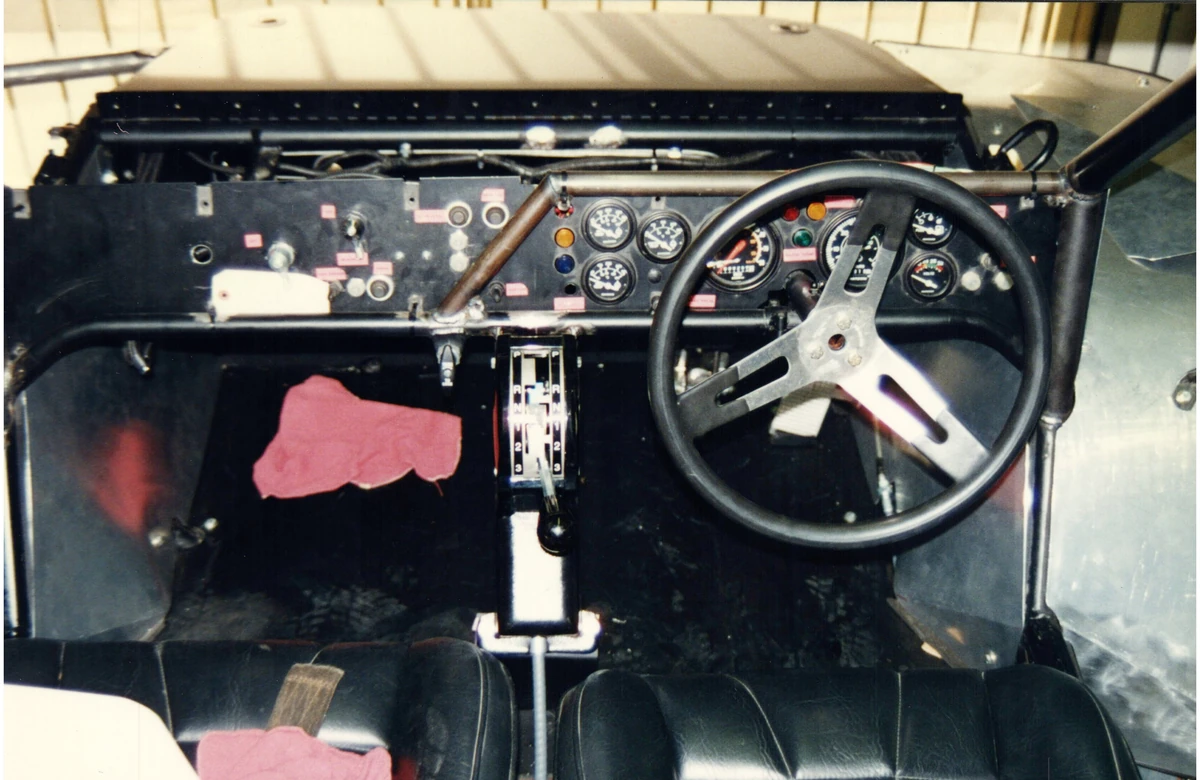 A close view of an early vehicle dashboard, gear selector and steering wheel
