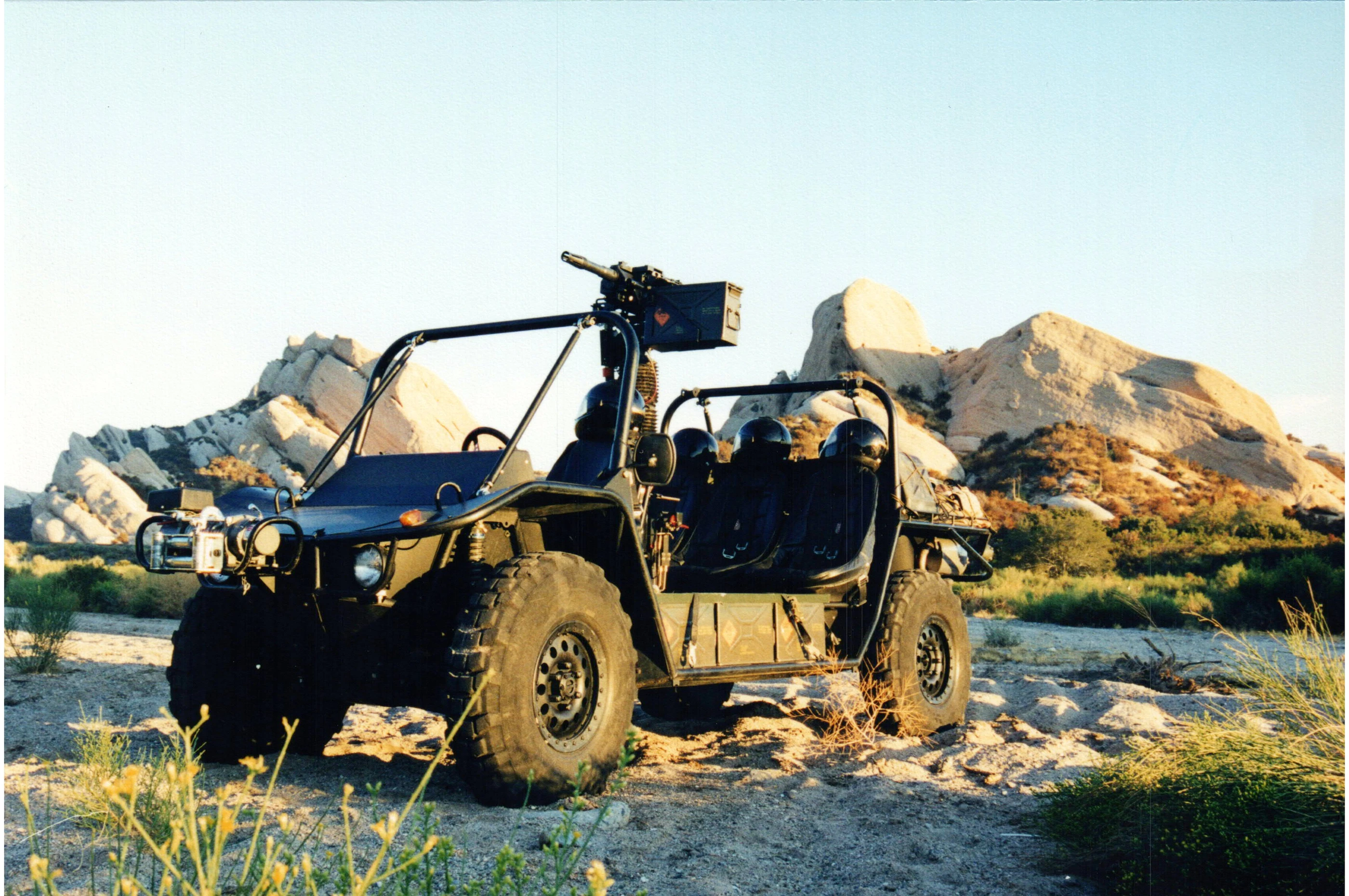 An early open-cab Flyer vehicle photographed in front of a rocky desert landscape