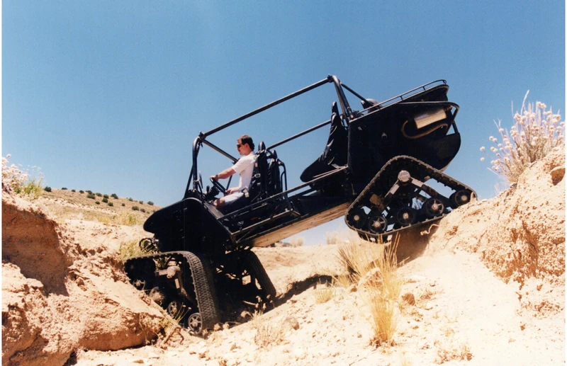 A Flyer fitted with tracks negotiating a steep dirt channel